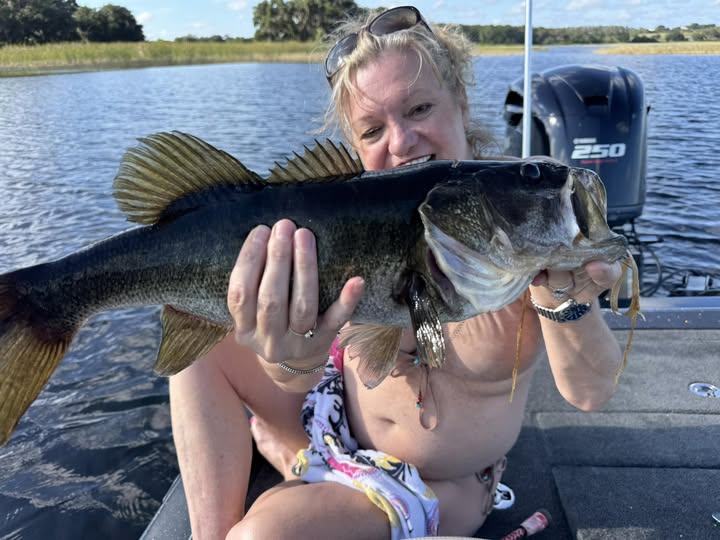 Woman angler holding a nice largemouth bass caught on Johns Lake, Florida
