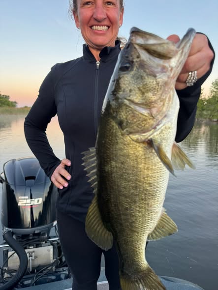 Woman angler holding a nice largemouth bass caught on the Harris Chain of Lakes, Florida